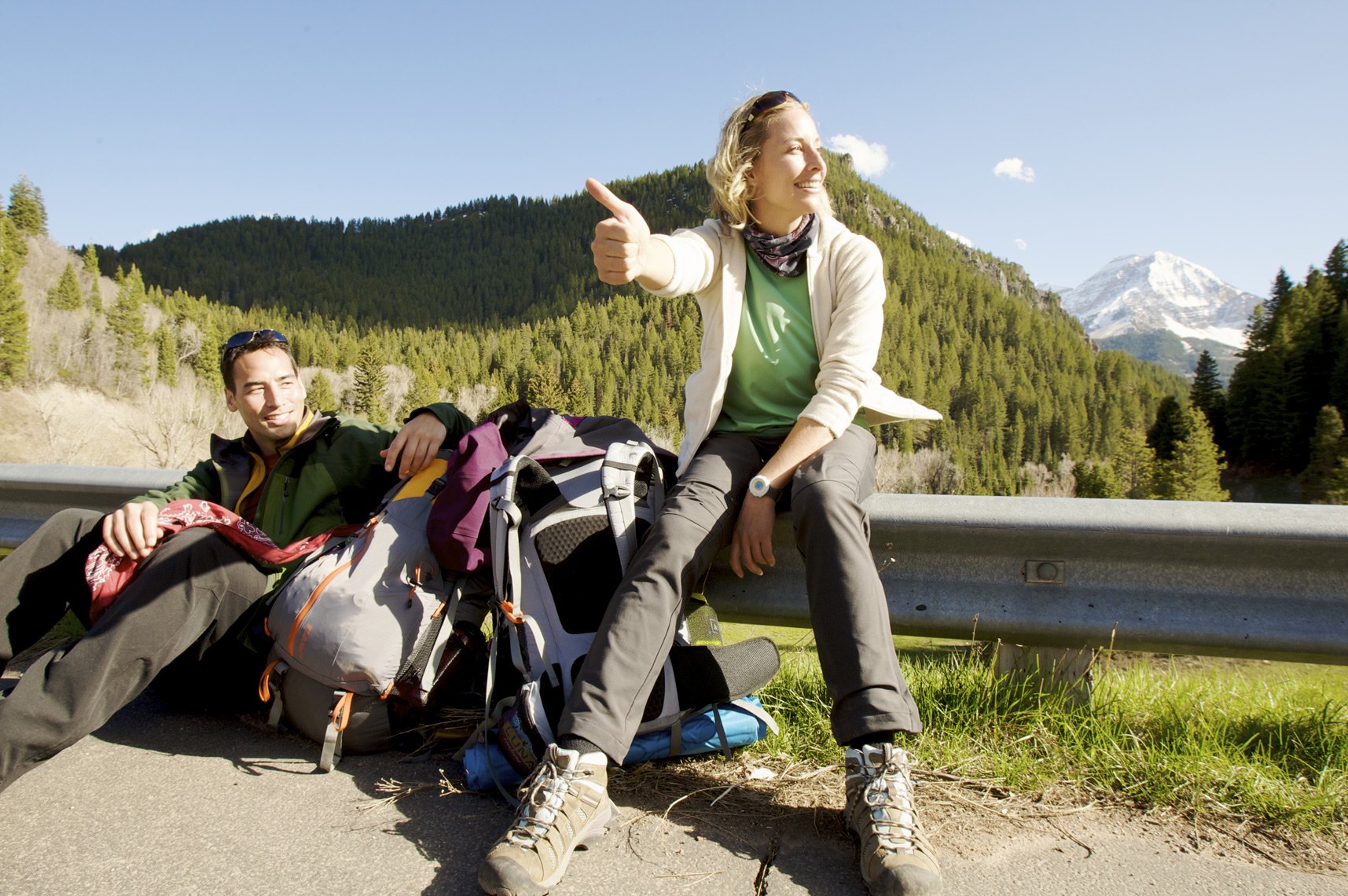 Couple of hikers hitchhiking in Utah after a trip in the backcountry/Steve Mason Photography