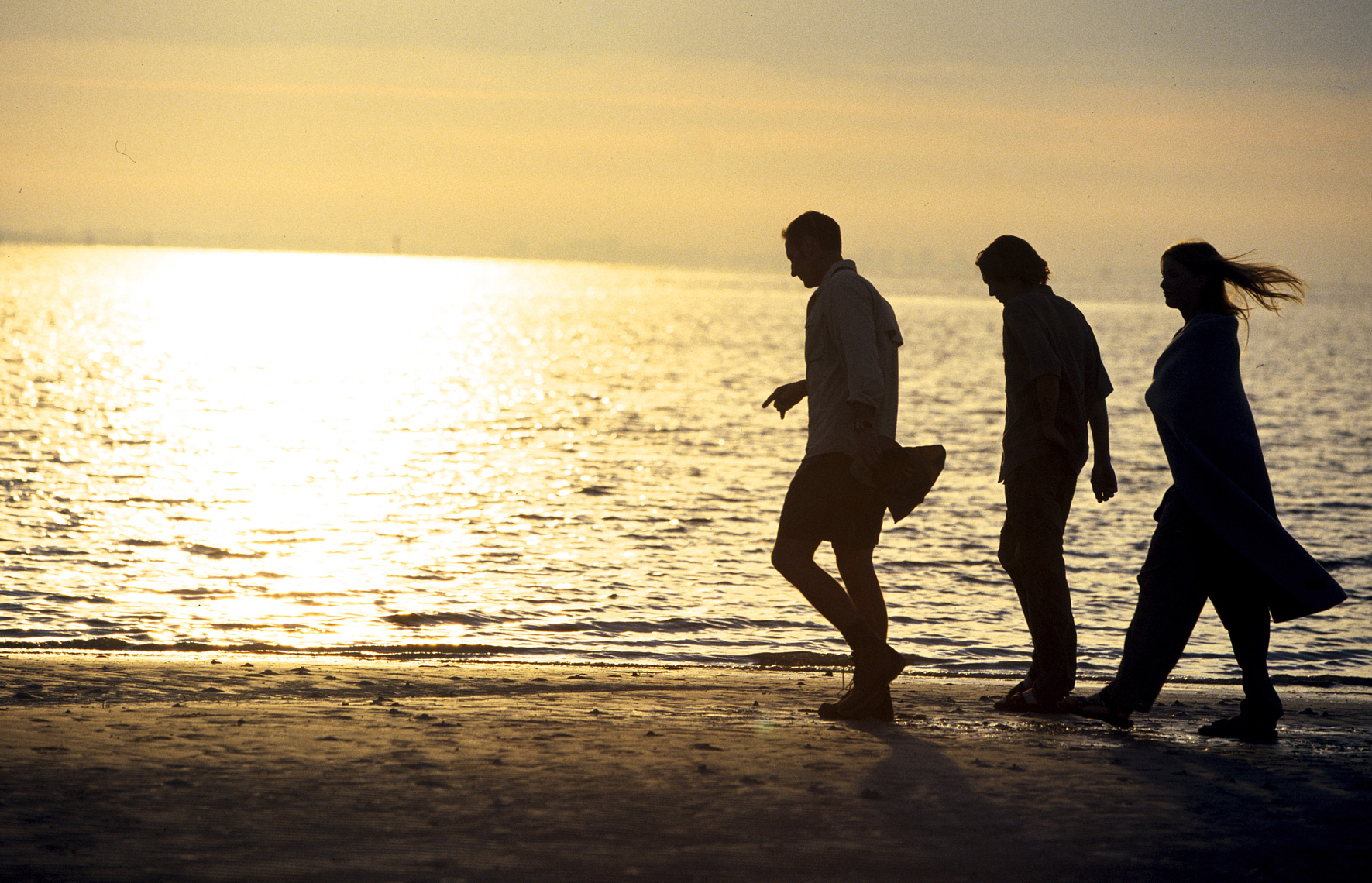 Three friends walk the beach at sunset on Sanabel Island/Steve Mason Photography